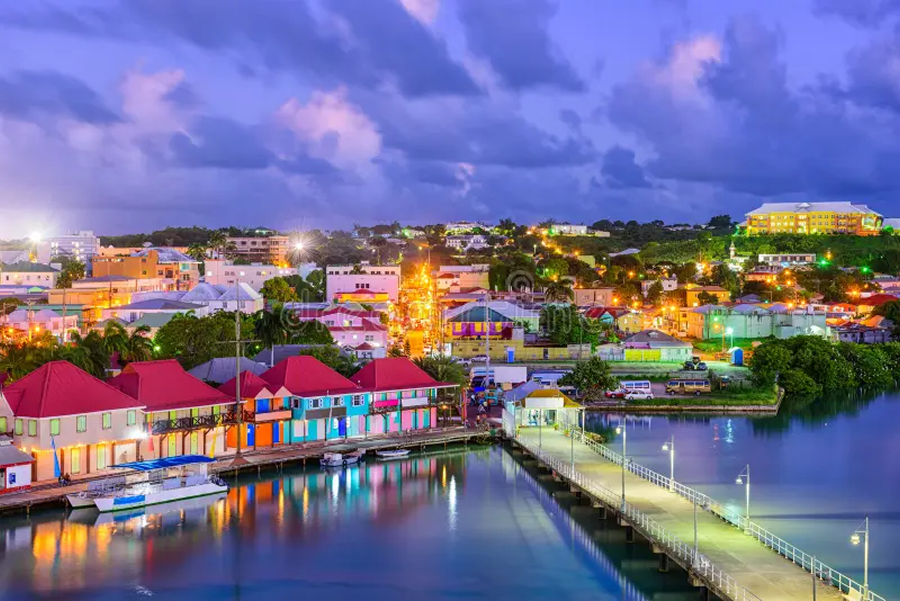 Wide view of Capital City, St. John's, colorfully vibrant architecture in Antigua and Barbuda illuminated at night.